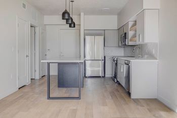 a renovated kitchen with white cabinets and stainless steel appliances